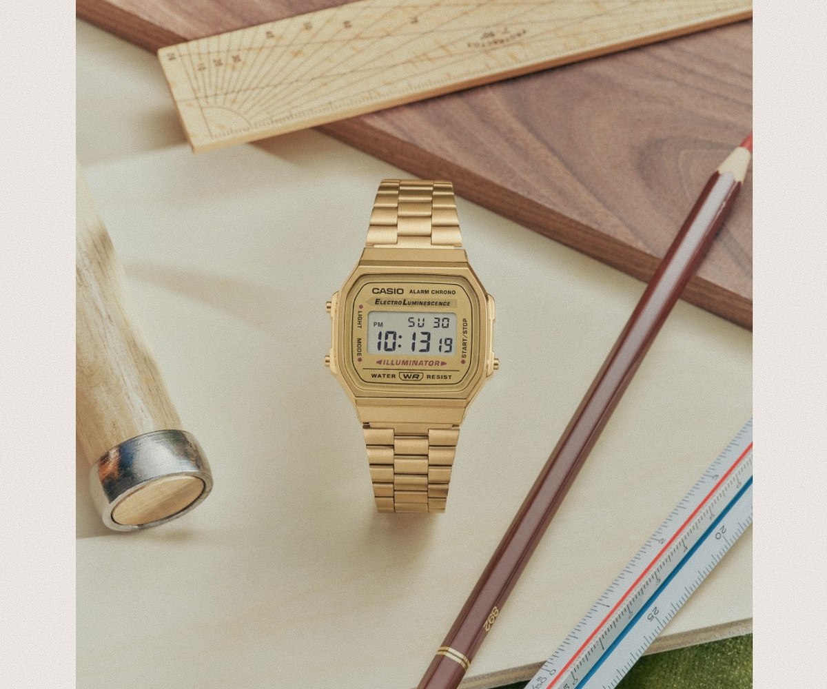 Gold Casio watch in a still life on a light-colored desk