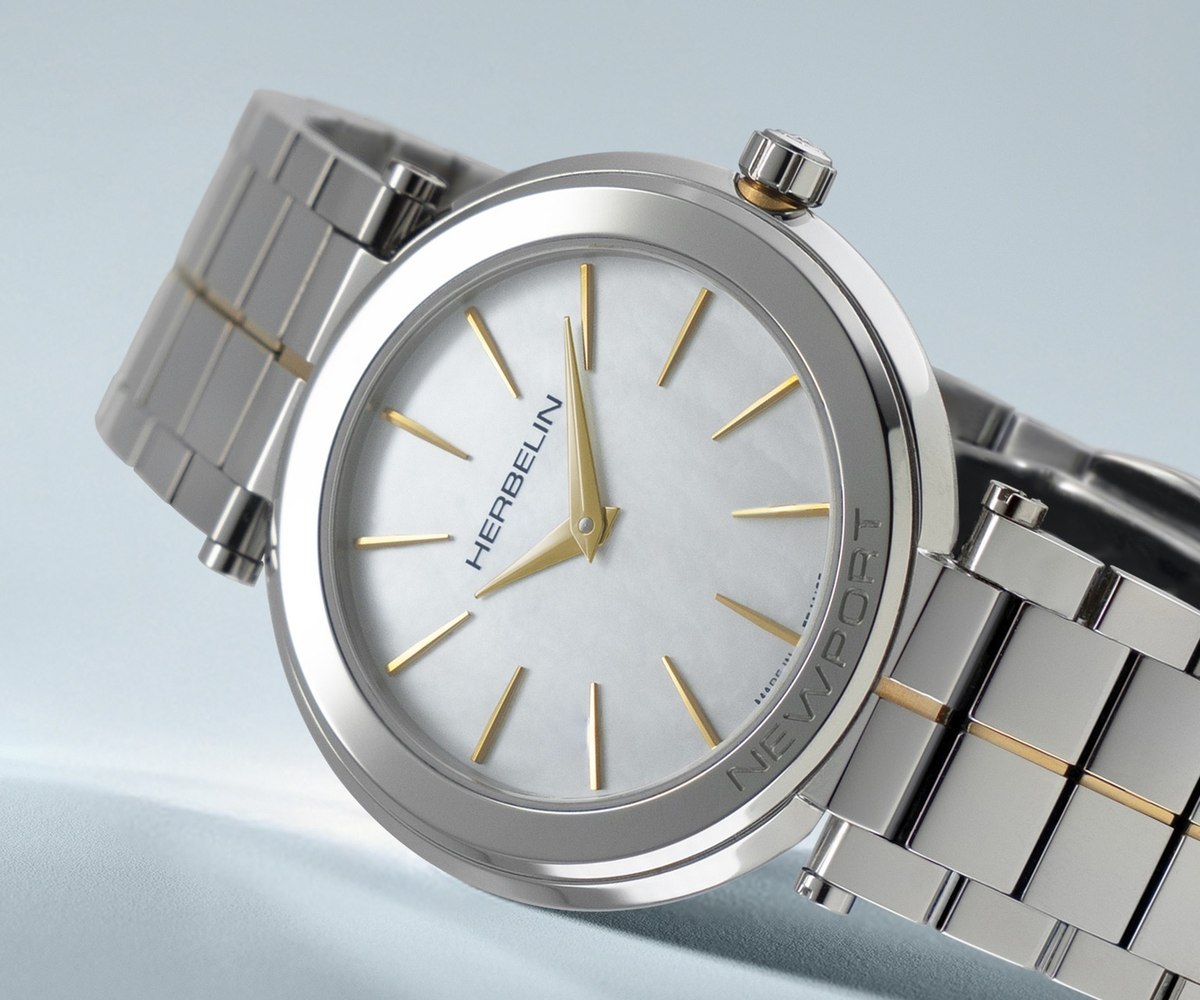 Close-up of the white mother-of-pearl dial on a Michel Herbelin watch