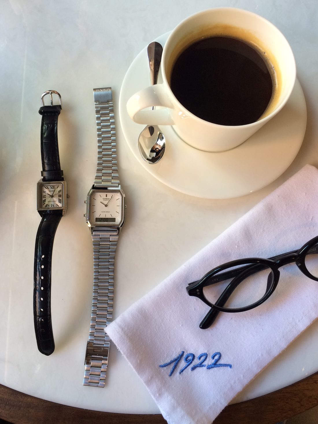 Cafe en terrasse avec deux montres Casio vintage posees sur la table