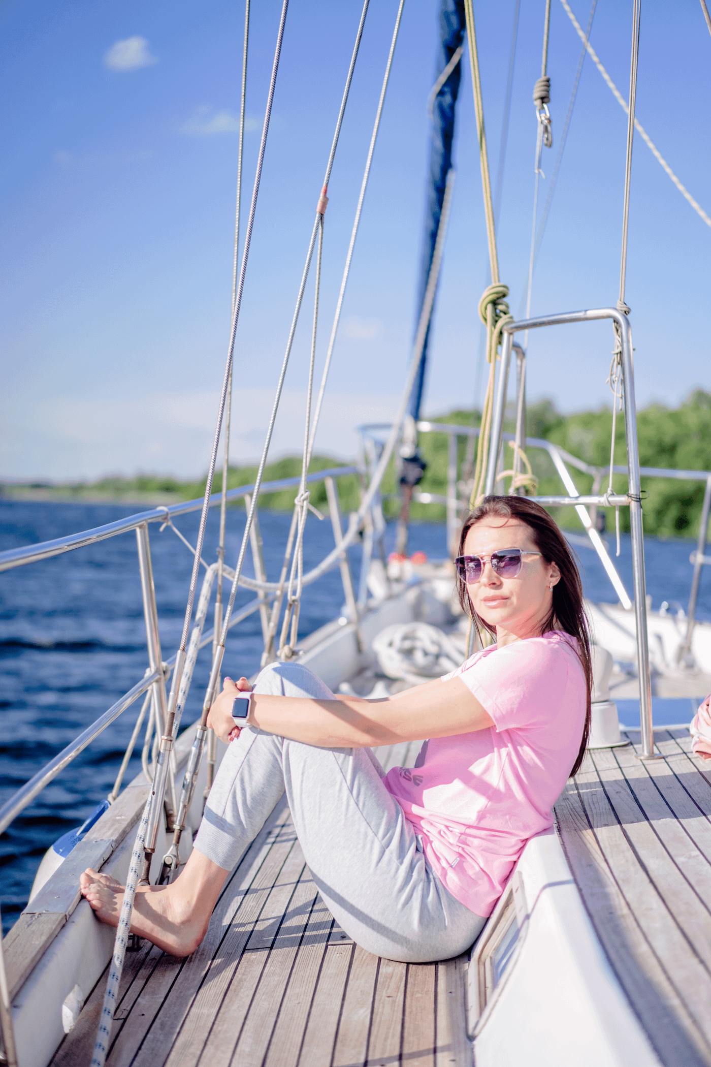 Femme en robe a pois assise a la proue d'un yacht