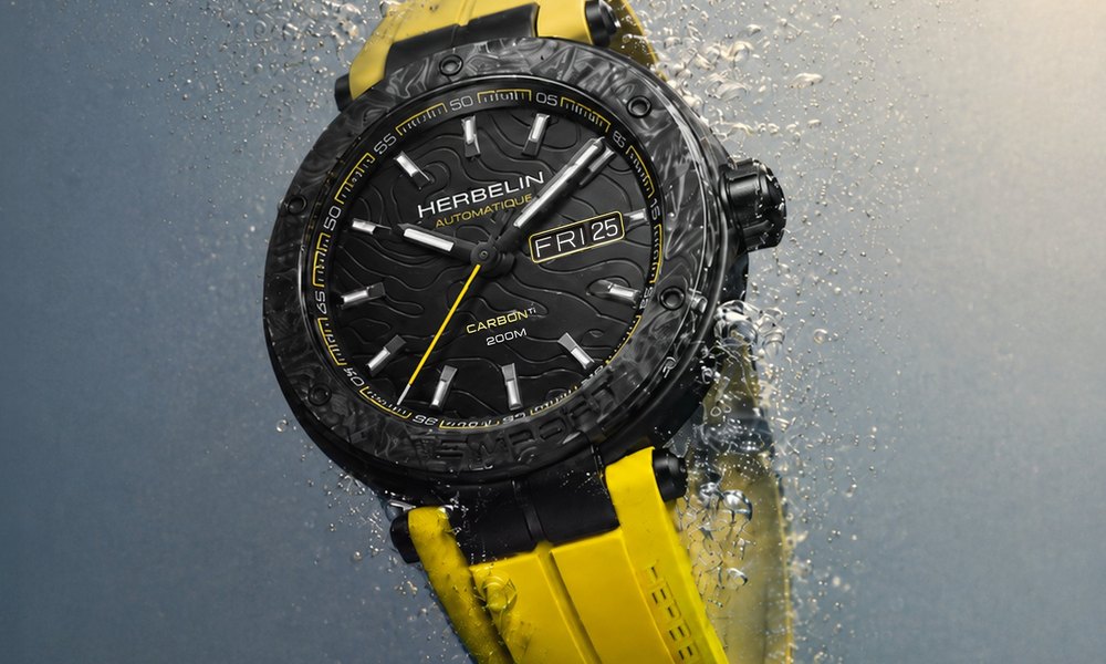 Montre Michel Herbelin carbone 200M avec bracelet caoutchouc jaune, gouttes d'eau et grains de sable