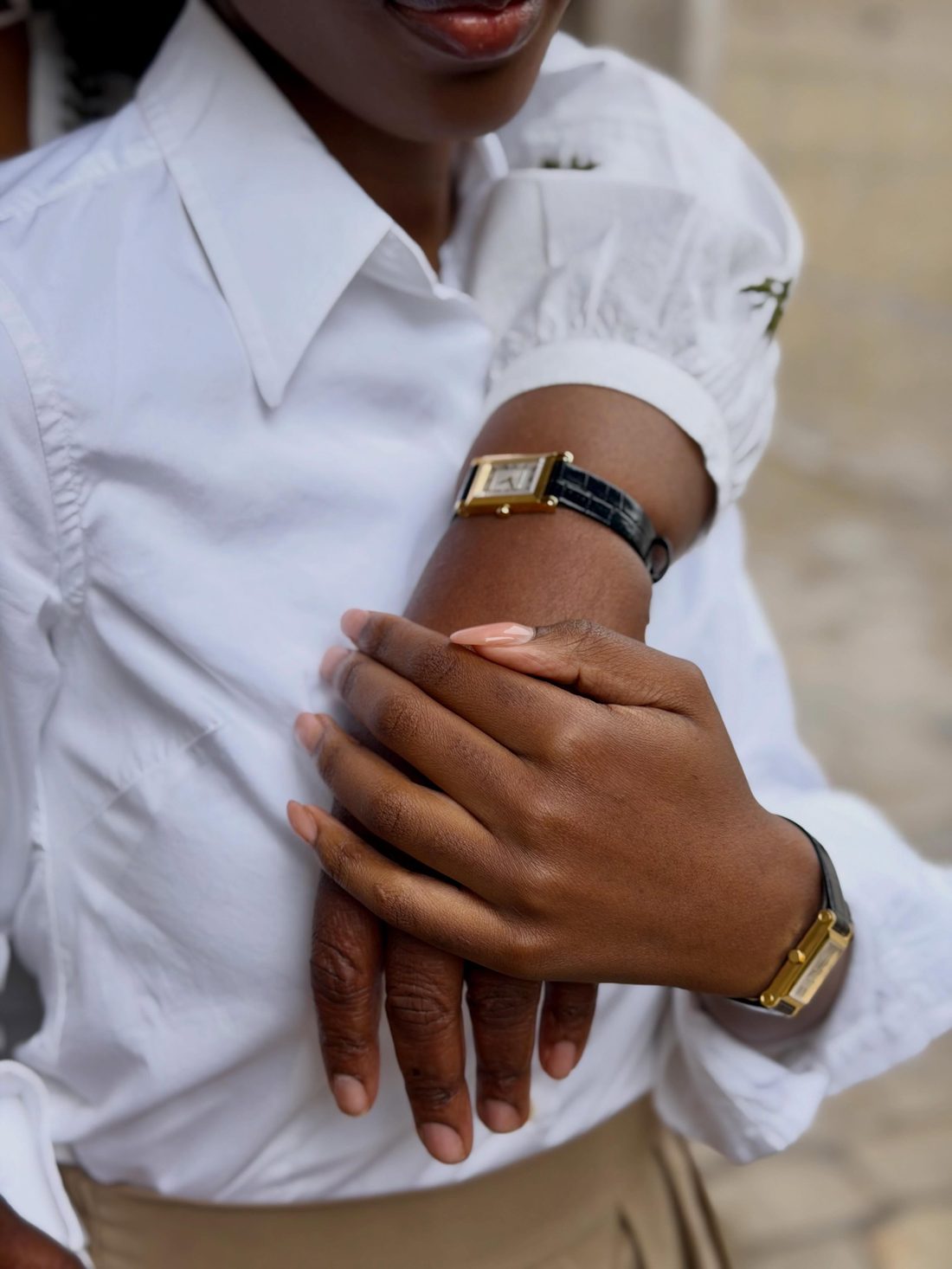 Femme en chemise blanche portant une montre Michel Herbelin doree