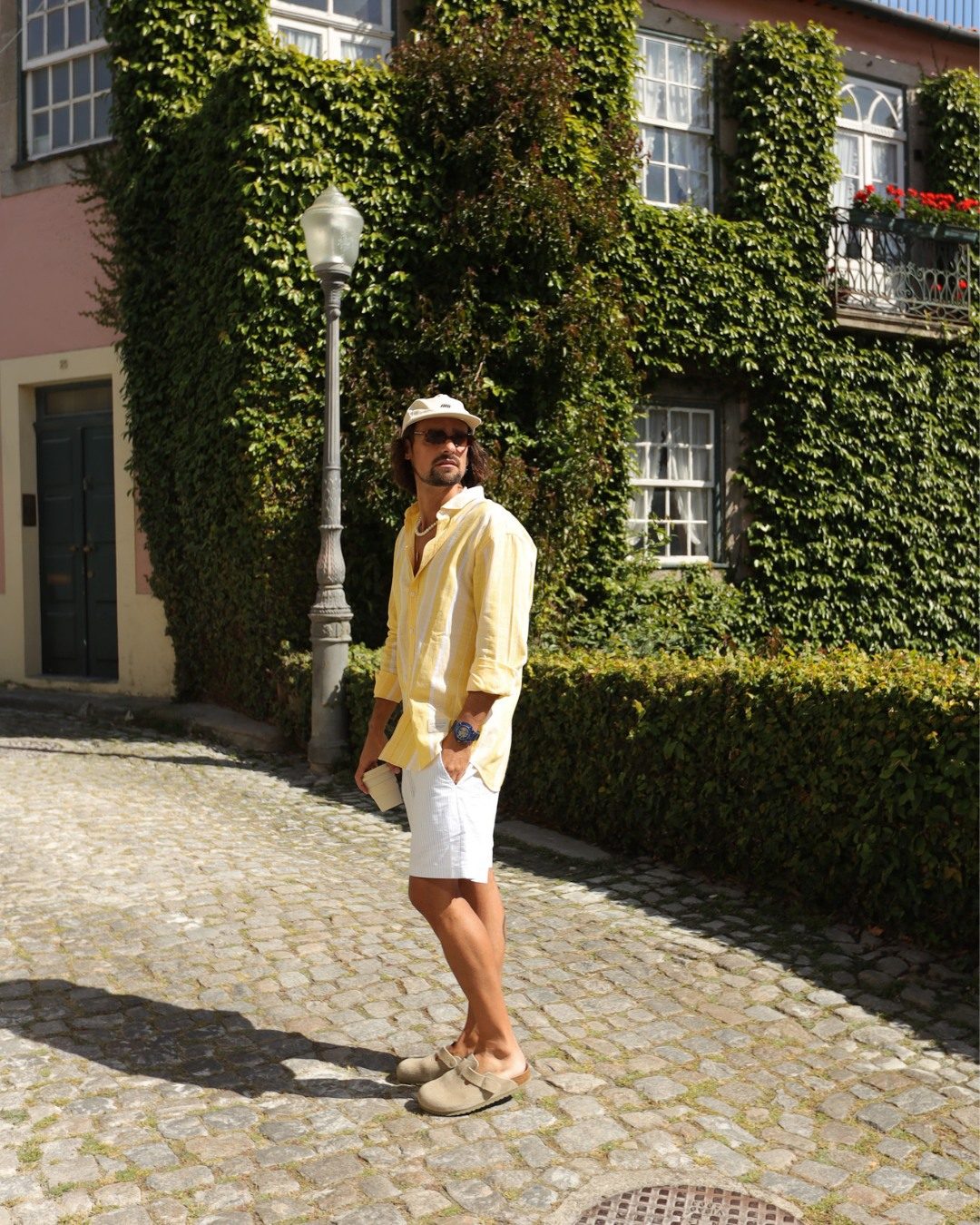 Homme en chemise jaune dans une ruelle ensoleillee portant une Ice-Watch