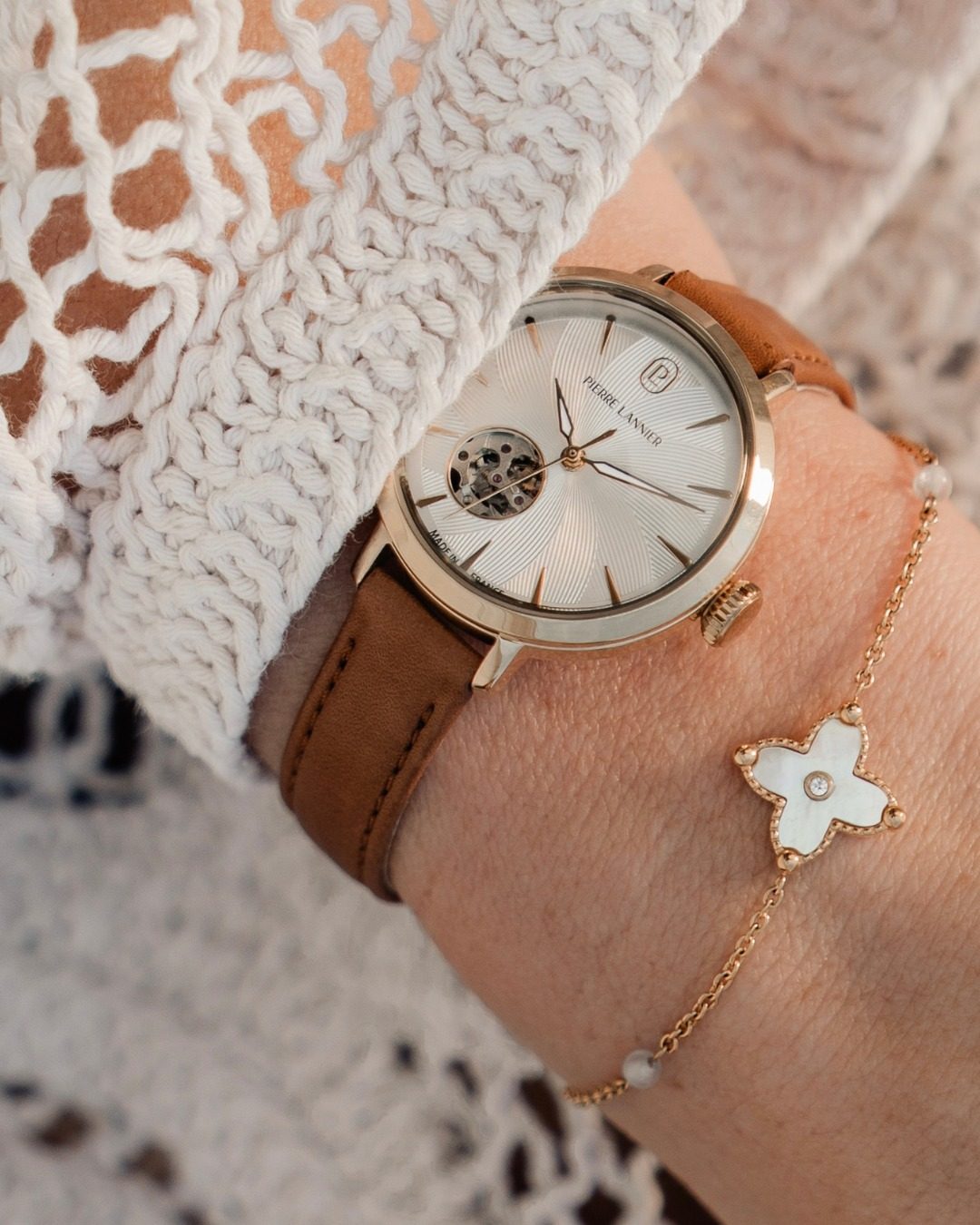 Montre Pierre Lannier doree au cadran vert posee sur un bouquet de marguerites