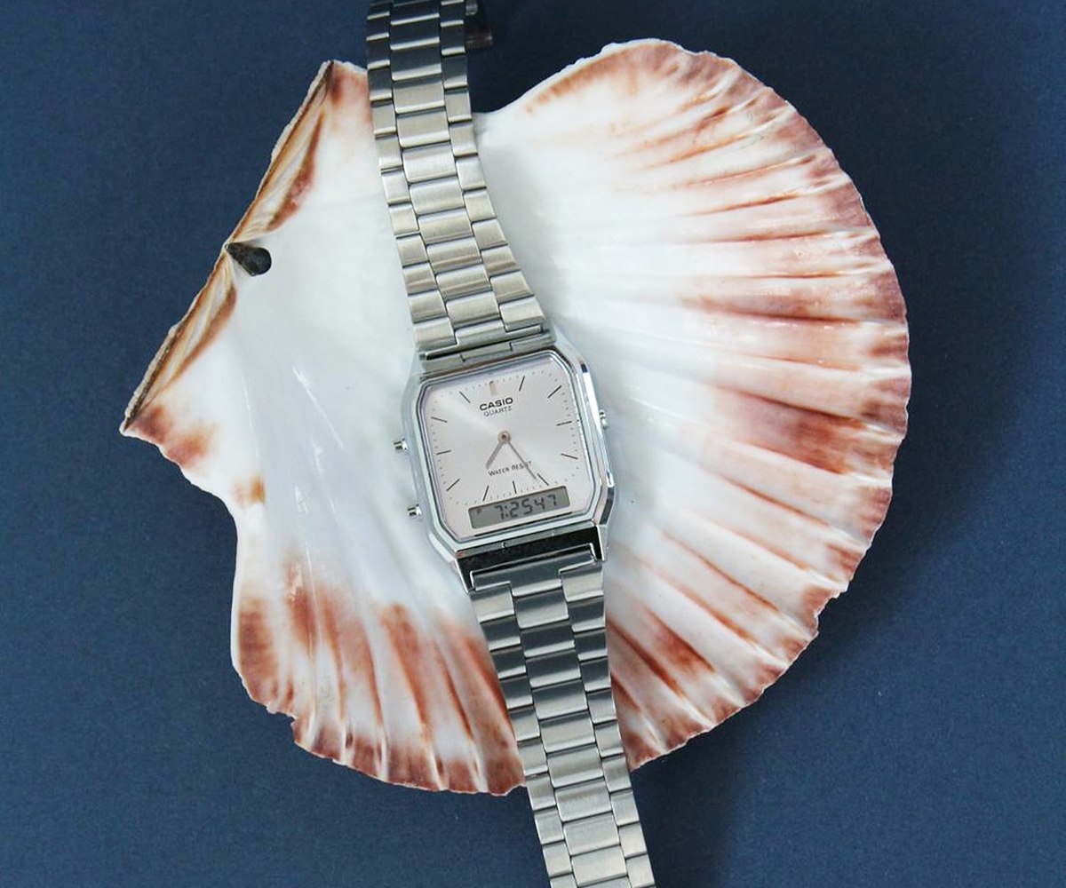 Montre Casio pos&eacute;e dans un coquillage sur fond bleu