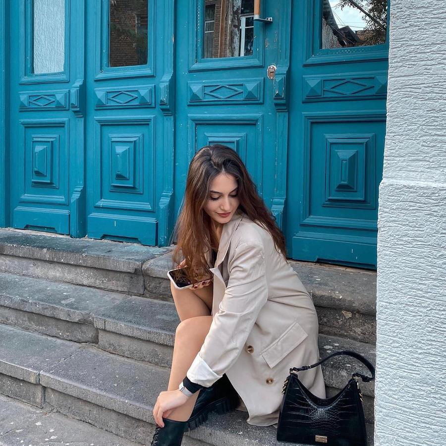 Daniel Wellington, Quadro et trench devant une porte turquoise