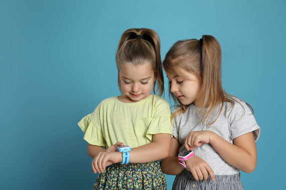 Deux enfants jouant avec une montre connectée enfant