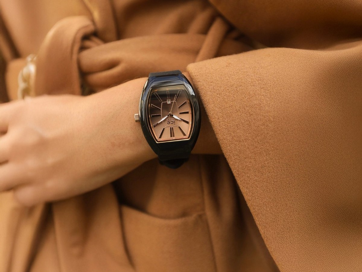 Montre tonneau Ice-Watch portée sur une manche de manteau camel