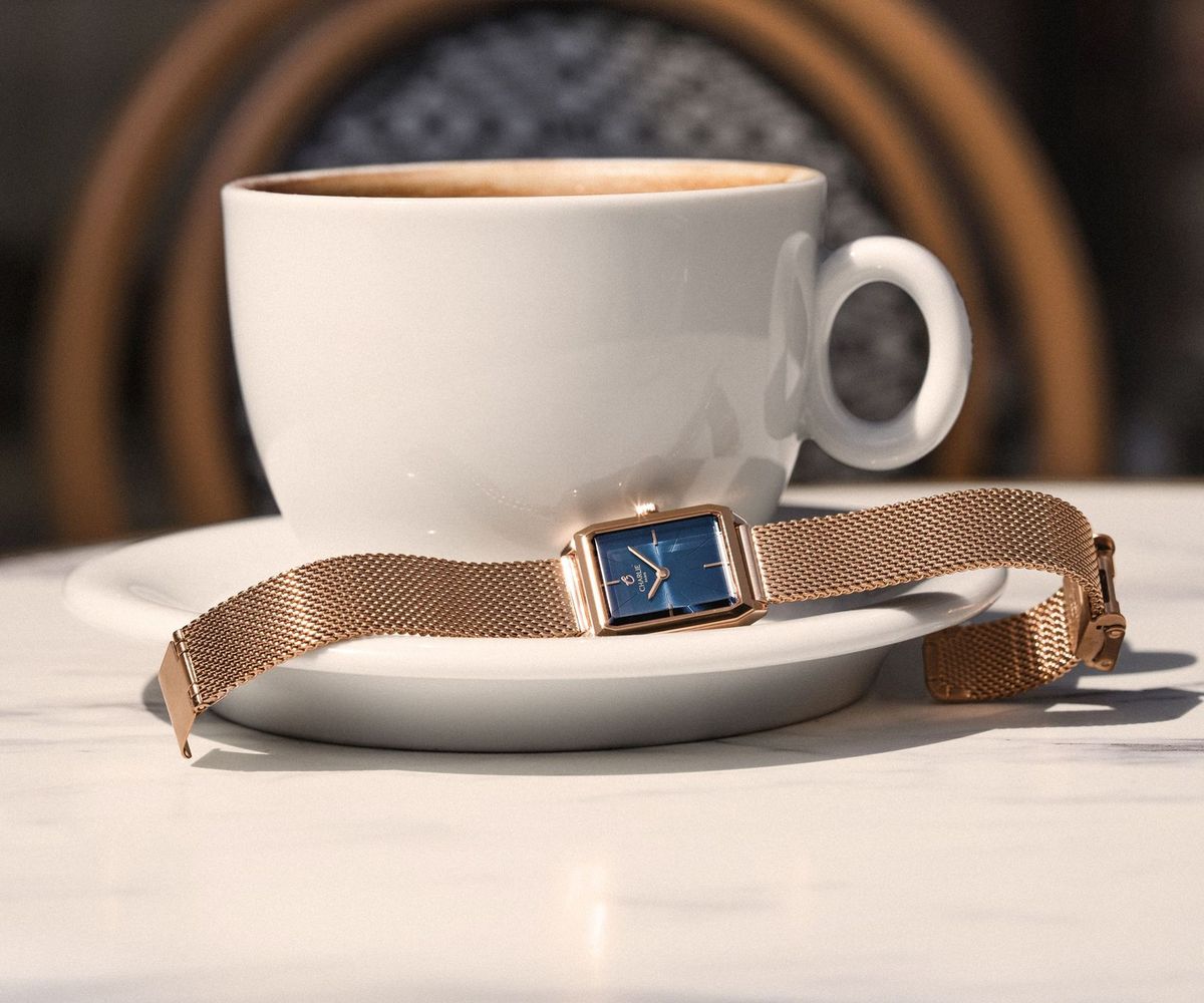 Montre Charlie Paris Monceau dorée rose cadran bleu sur une table de café