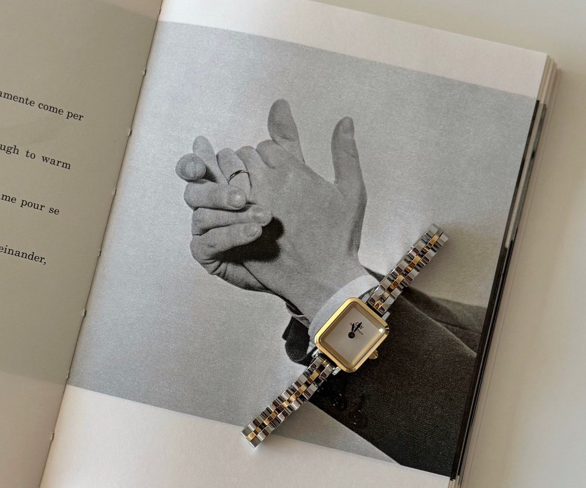 Montre bicolore Daniel Wellington posée sur un livre ouvert