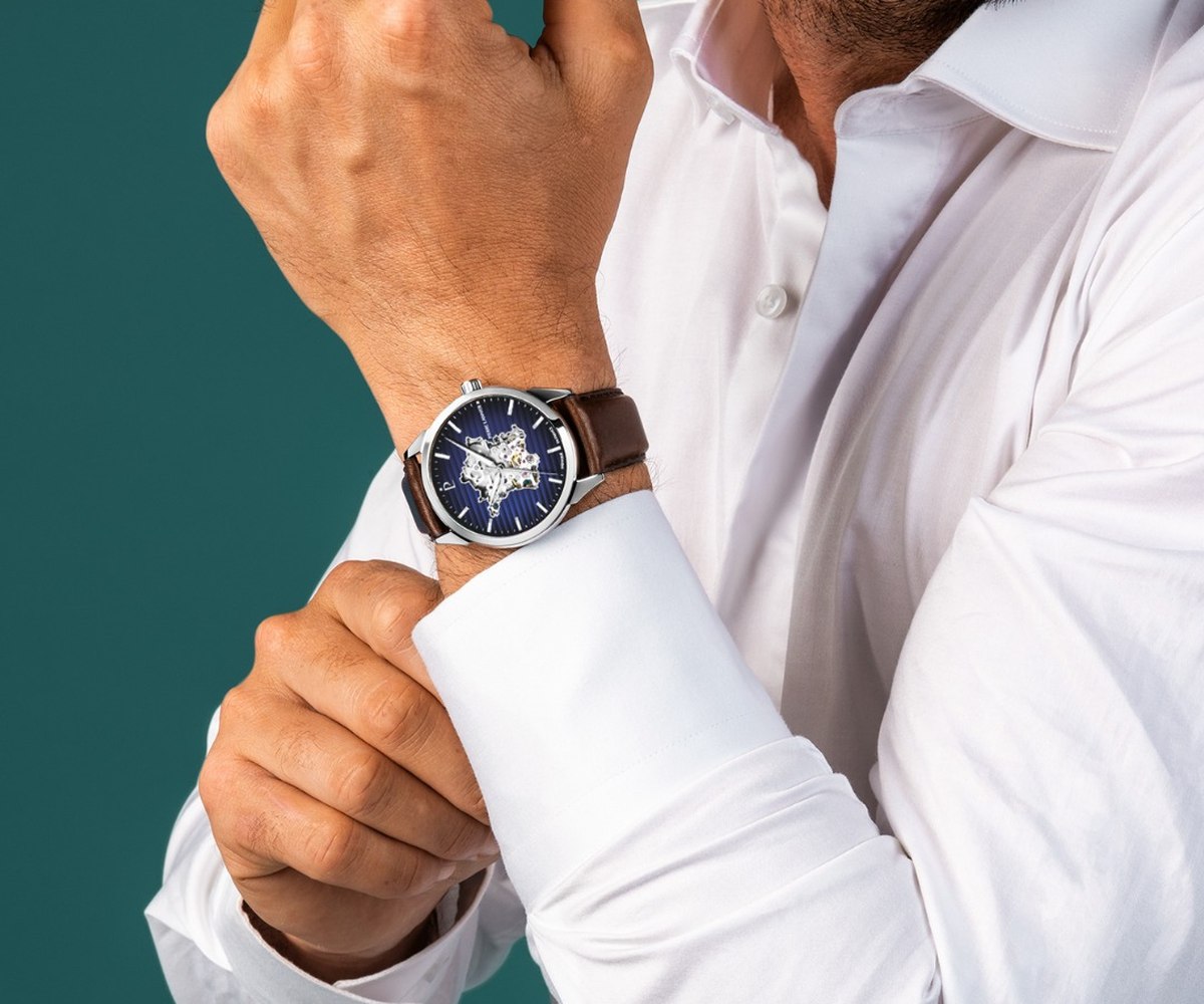 Montre squelette automatique portée au poignet avec une chemise blanche