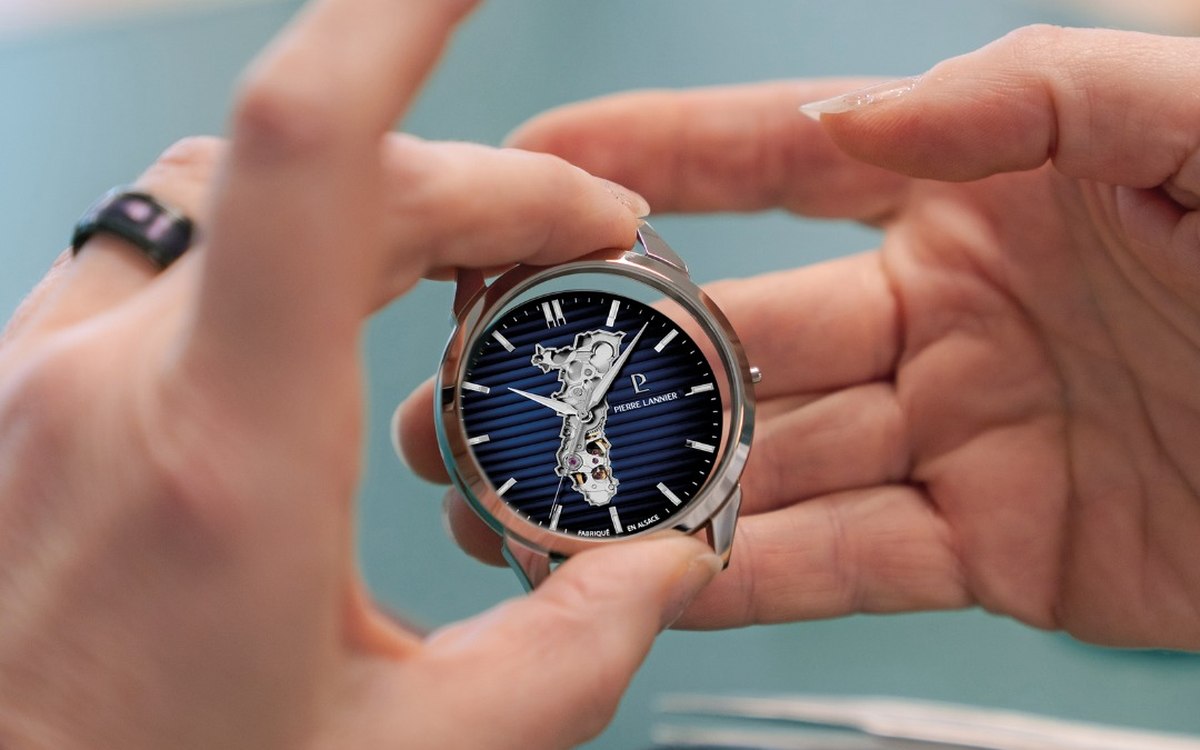 Montre squelette tenue &agrave; la main au-dessus d'un &eacute;tabli