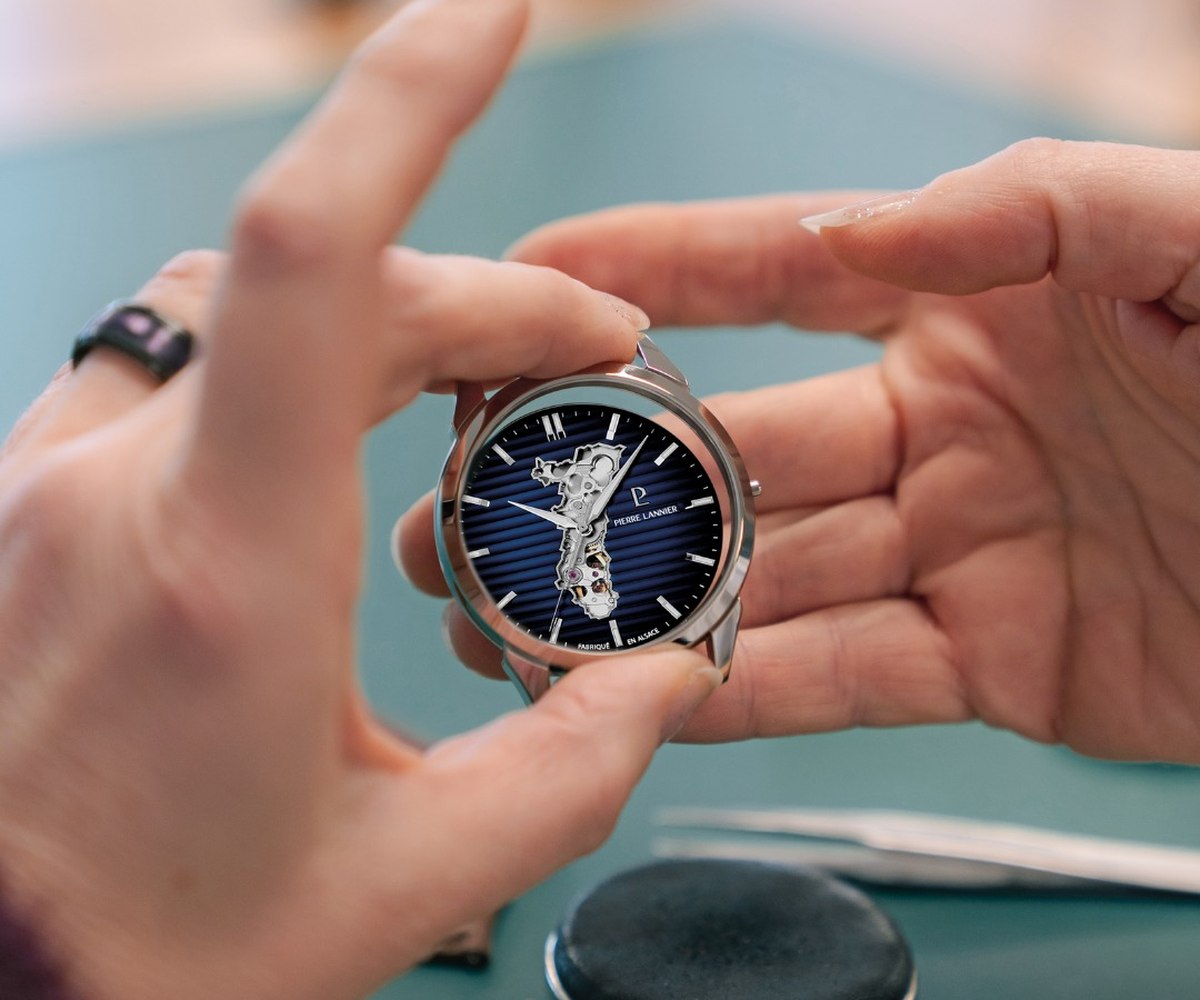 Montre squelette tenue à la main au-dessus d'un établi