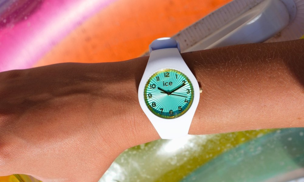 Montre Ice-Watch etanche portee au poignet, main posee sur une bouee dans une piscine