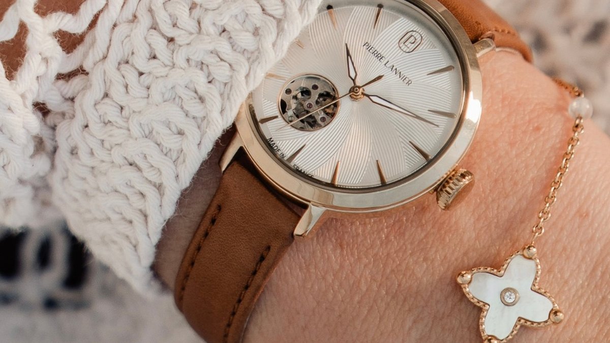Montre Pierre Lannier c&oelig;ur ouvert dor&eacute;e port&eacute;e avec une manche en dentelle blanche