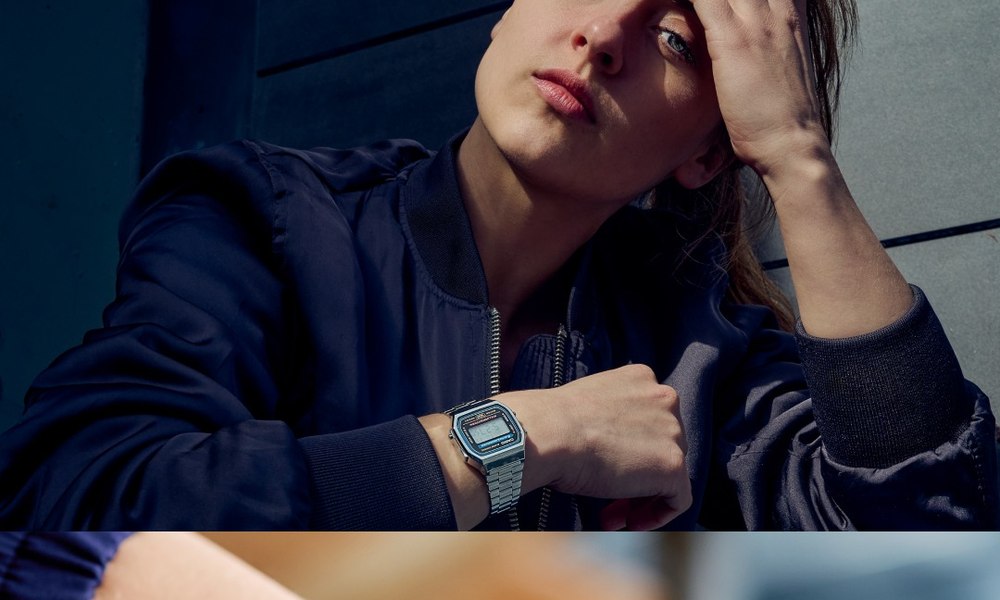 Montre digitale Casio en acier portee au poignet sous une veste bleue