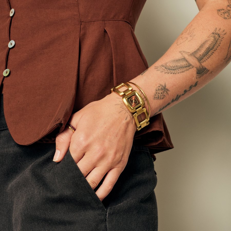Montre Nixon Sisi dor&eacute;e port&eacute;e au poignet avec un gilet de lin