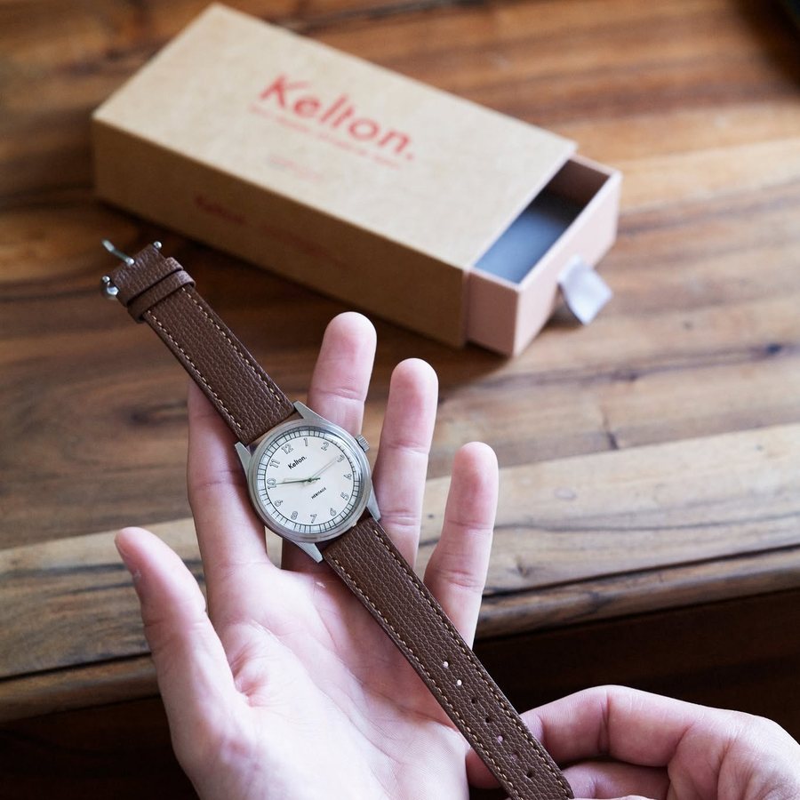 Montre sortie de sa bo&icirc;te, tenue dans la main
