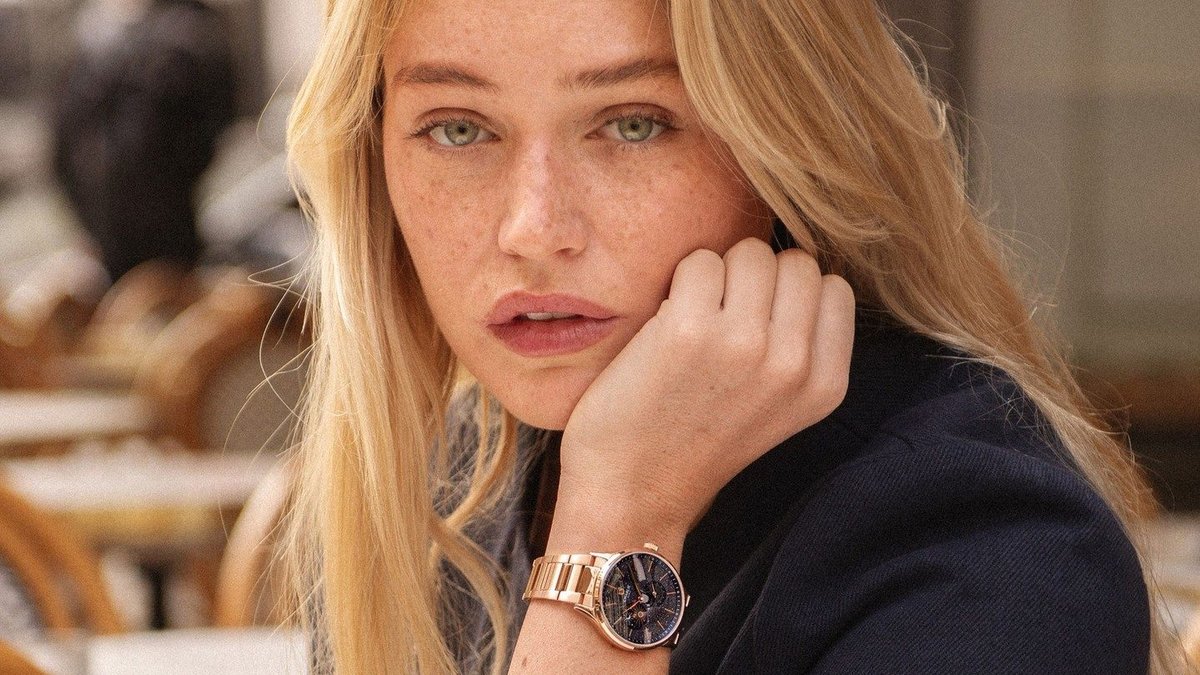 A rose gold women's watch worn at a café terrace—an original gift idea