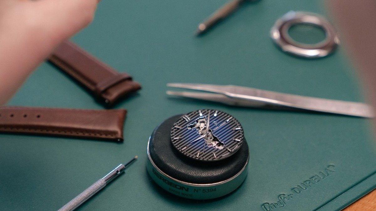 Etabli d'horloger avec cadran de montre fran&ccedil;aise, outils et bracelets cuir