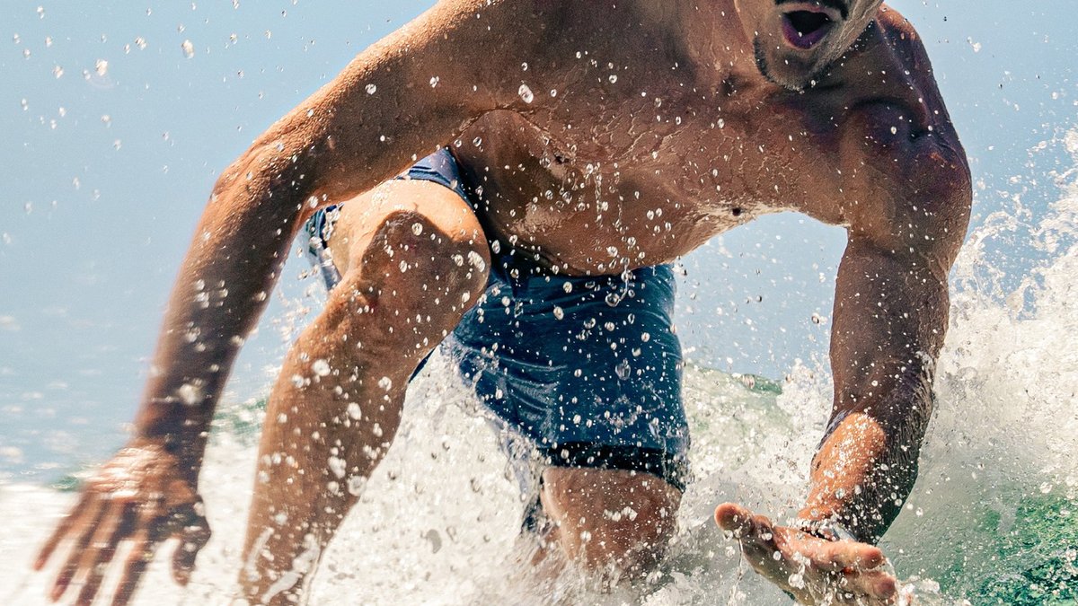 Homme portant une montre Charlie Paris dans la mer en été