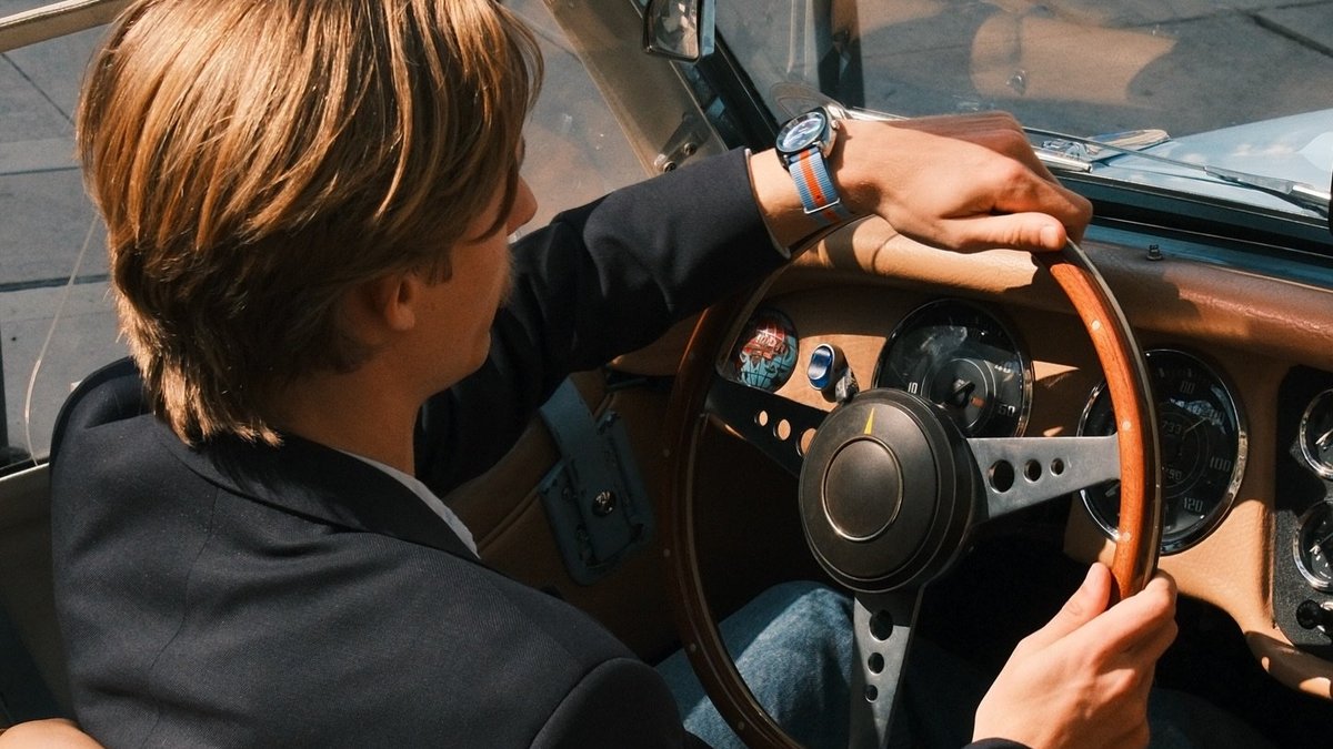 Montre vintage homme au poignet, au volant d'une voiture ancienne
