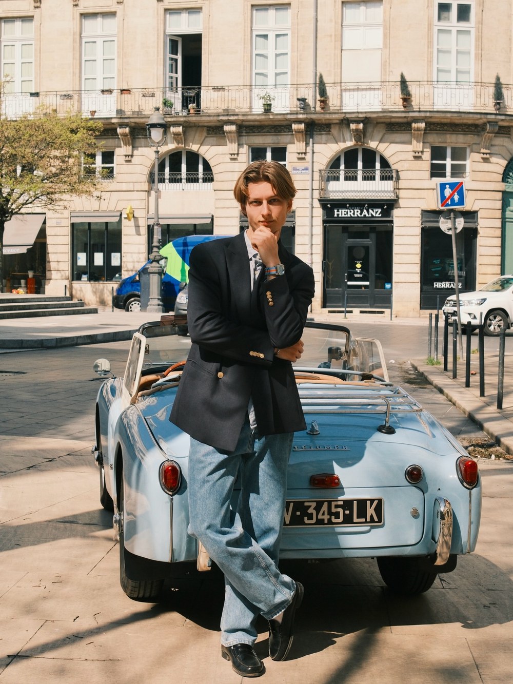 Montre Kelton au poignet devant un cabriolet ancien, rue parisienne