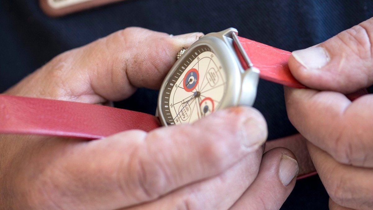 Artisan ajustant un bracelet cuir rouge sur un chronographe Kelton x Chapal