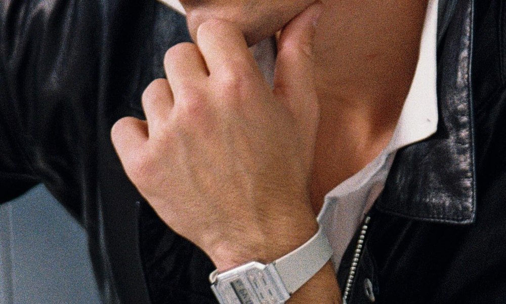 Homme en veste de cuir et chemise blanche portant une montre a boitier carre clair